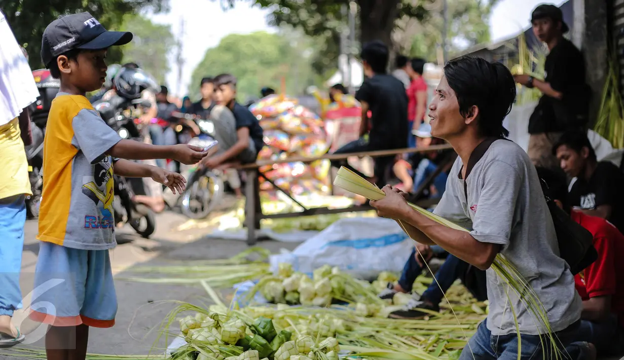Seorang anak kecil membeli kulit ketupat di sebuah pasar kawasan Ciracas, Jakarta, Kamis (16/7/2015). Menjelang Lebaran, warga mulai ramai membeli kulit ketupat. (Liputan6.com/Faizal Fanani)