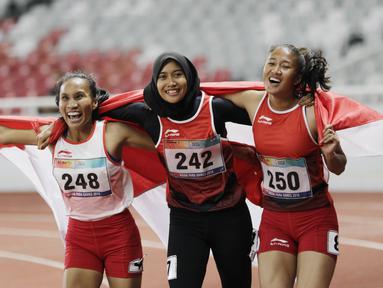 Pelari Indonesia, Putri Aulia, Ni Made Arianti, Endang Sari Sitorus, melakukan selebrasi usai menjuarai lari 100M T13 pada Asian Para Games di SUGBK, Jakarta, Rabu (10/10/2018). Indonesia meraih memborong tiga mendali. (Bola.com/M Iqbal Ichsan)