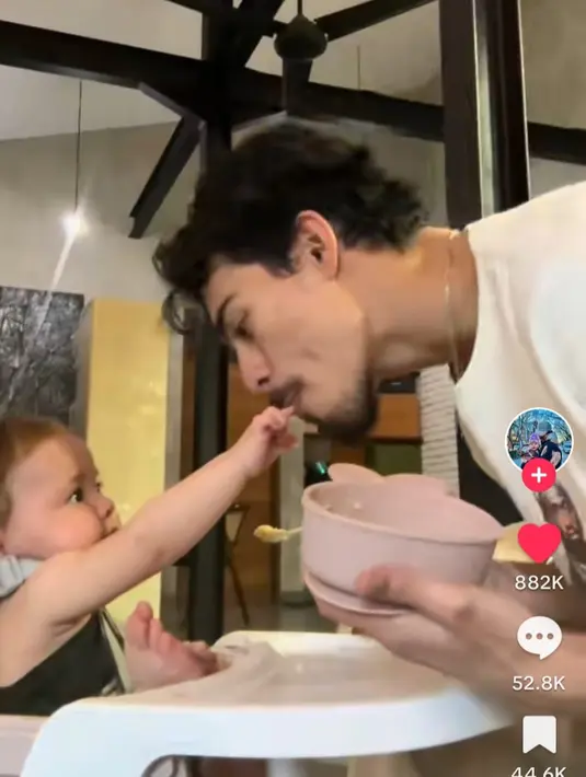 <p>Dali bermain-main dengan sang anak sambil menyuapi. Dia mencium tangan sang buah hati tercinta. (Foto: TikTok/ dali.wassink)</p>