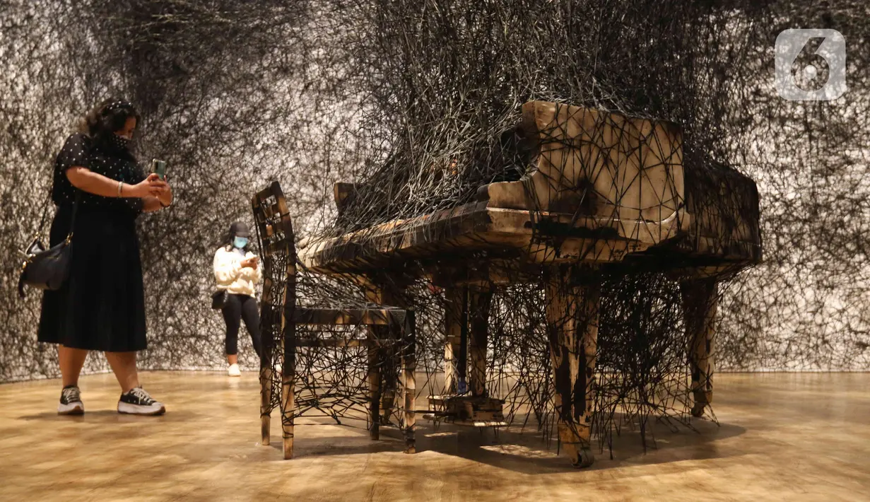 Pengunjung melihat karya seni instalasi yang ditampilkan dalam pameran bertajuk The Soul Trembles di Museum Modern and Contemporary Art in Nusantara (MACAN), Jakarta, Selasa (3/01/2023). Pameran tunggal karya perupa asal Jepang, Chiharu Shiota itu akan dibuka untuk publik mulai 26 November 2022 hingga 20 April 2023. (Liputan6.com/Herman Zakharia)
