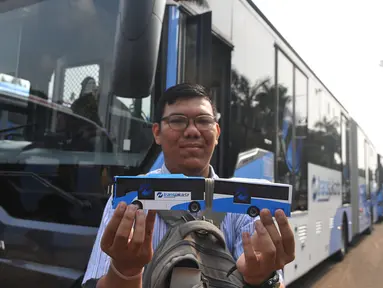 Warga memperlihatkan miniatur Bus transjakarta bermerek Scania saat acara peluncuran di Silang monas, Jakarta, Senin (22/6/2015). Ada sebanyak 20 unit bus transjakarta bermerek Scania yang diluncurkan pertengahan Juni ini. (Liputan6.com/Herman Zakharia)