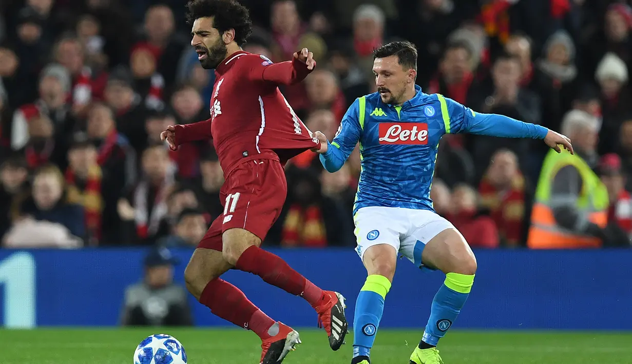 Gelandang Liverpool, Mohamed Salah, berusaha melewati bek Napoli, Mario Rui, pada laga Liga Champions di Stadion Anfield, Liverpool, Selasa (11/12). Liverpool menang 1-0 atas Napoli. (AFP/Paul Ellis)