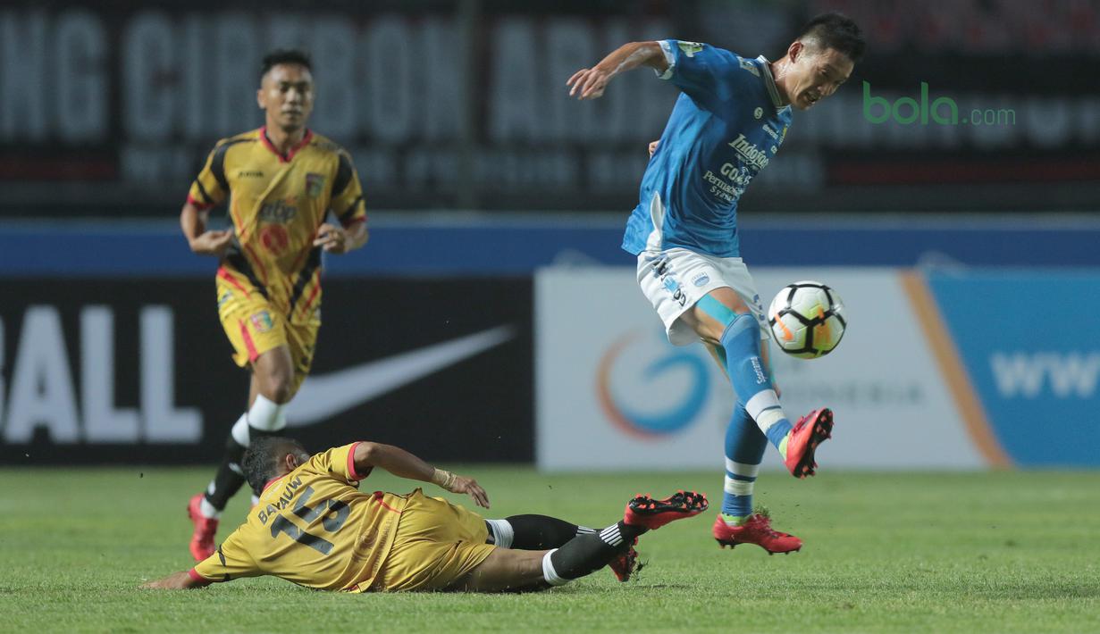 Pemain Persib Bandung, Oh In-kyun menghindari terjangan pemain Mitra Kukar, Hendra Bayauw pada laga Liga 1 Indonesia di GBLA, (8/4/2018). Persib Bandung menang 2-0. (Bola.com/Nick Hanoatubun)