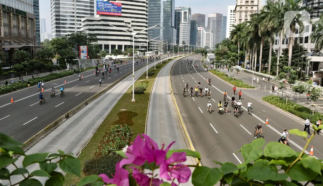 Warga berolahraga saat kegiatan Car Free Day (CFD) di Kawasan Sudirman, Jakarta, Minggu (21/6/2020). Pada CFD pertama di masa PSBB Transisi, warga Ibu Kota terlihat lebih memilih bersepeda sebagai sarana olahraga dengan tetap menerapkan protokol kesehatan Covid-19. (merdeka.com/Iqbal Nugroho)