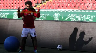 Pemain timnas Mesir Mohamed Salah bersama tim kesehatan melatih bahunya selama sesi pelatihan di stadion Akhmat Arena di Grozny (12/6). Meski masih dibekap cedera bahu, Salah tetap optimis dapat tampil di Piala Dunia 2018 Rusia. (AFP Photo/Karim Jaafar)