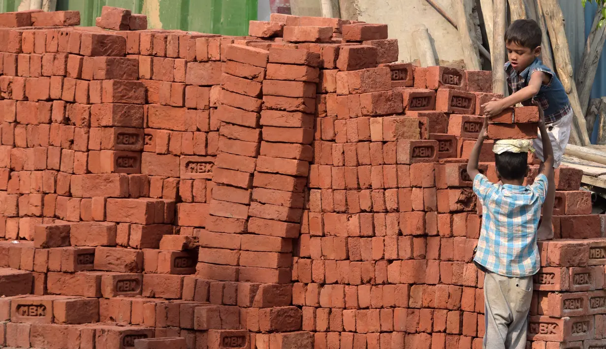 Dua orang anak mengangkat batu batu di sebuah bangunan New Delhi, Minggu (19/11). Pada 2015, Organisasi Buruh Internasional (ILO) menyebutkan, pekerja anak India berjumlah sekira 5,7 juta dengan usia antara lima sampai dengan 17 tahun. (DOMINIQUE FAGET)