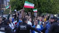 Suporter Timnas Iran melambaikan tangan saat para pemain tiba untuk Piala Dunia di Tijuana, Meksiko, Minggu, 7 Juni 2026. (AP Photo/Gregory Bull)
