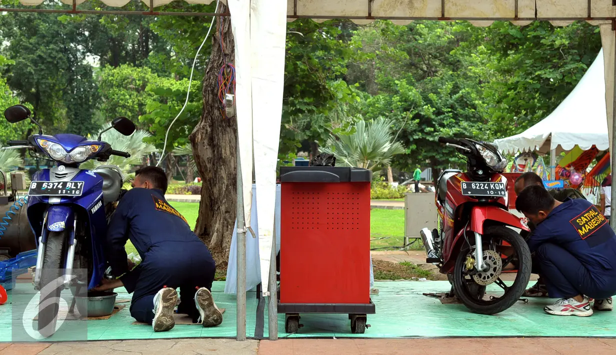 Sejumlah anggota TNI saat melakukan service sepeda motor gratis di kawasan Lapangan Banteng, Jakarta, Jumat (11/12). Kegiatan ini memperingati Hari Juang Kartika Tahun 2015 dan berlangsung sampai hari Minggu (13/12). (Liputan6.com/Faisal R Syam)