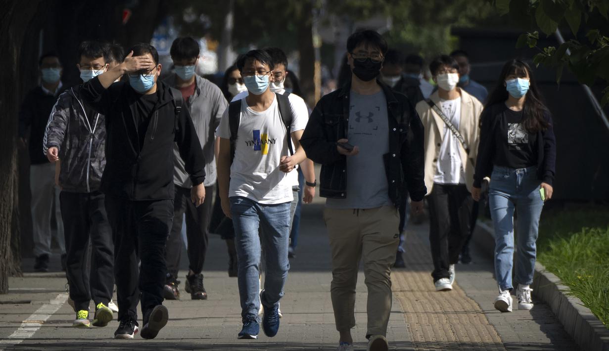 <p>Penumpang yang mengenakan masker berjalan menuju kawasan pusat bisnis dari stasiun kereta bawah tanah yang belum ditutup di Beijing, Kamis (5/5/2022). Ibu kota China Beijing pada Kamis (5/5) mulai melonggarkan aturan karantina untuk kedatangan dari luar negeri. (AP Photo/Mark Schiefelbein)</p>