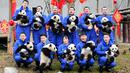 Penjaga menggendong anak-anak panda saat berpose untuk merayakan Tahun Baru Imlek yang dikenal sebagai Tahun Babi, di provinsi Sichuan, China, 31 Januari 2019. 11 anak panda yang lahir pada 2018 diperlihatkan kepada publik untuk menyambut Imlek. (STR/AFP)