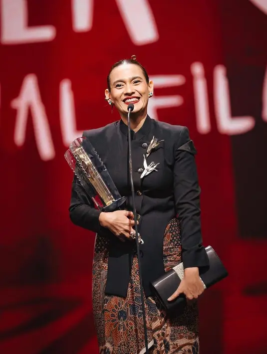 Ine Febriyanti kenakan kebaya Janggan hitam saat meraih piala FFI 2023 sebagai aktris terbaik. Dipadukan dengan kain Batik dan bros bergambar burung. [@hagaipakan]