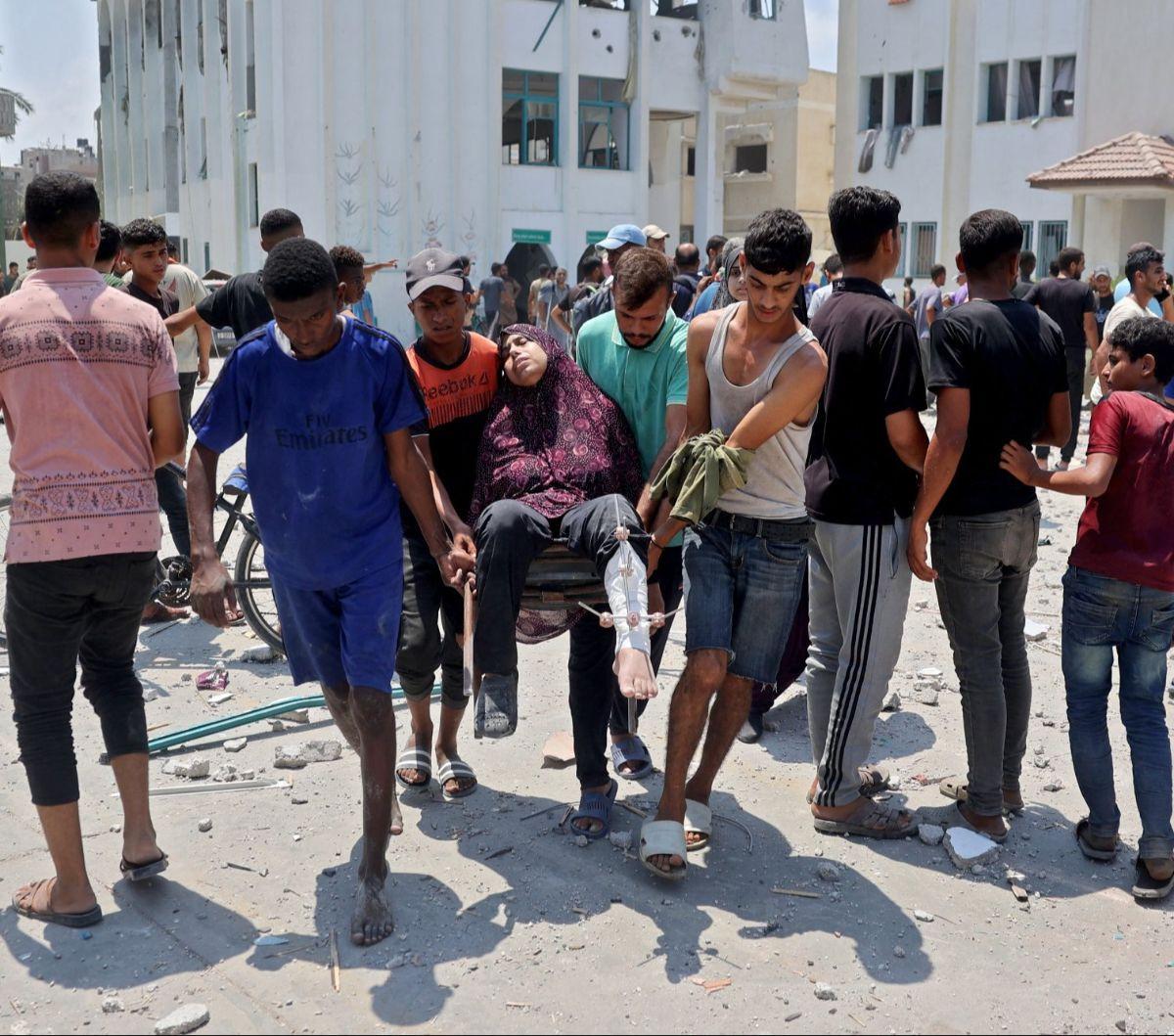 Seorang wanita Palestina yang terluka dibawa ke ambulans setelah serangan udara Israel menghantam sekolah Khadija di Deir al-Balah, Jalur Gaza, Palestina, pada 27 Juli 2024. Israel lagi-lagi menargetkan sekolah yang jadikan kamp pengungsian dalam serangan