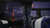 Menara Tokyo terlihat melalui jendela bus menjelang Olimpiade Musim Panas 2020 di Tokyo pada 15 Juli 2021. Di bawah protokol yang ketat, satu-satunya cara untuk melihat sekilas ibu kota adalah dari kendaraan yang mengantar para tamu dari perkampungan atlet atau hotel ke venue. (AP Photo/Jae C Hong)