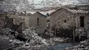 Reruntuhan bekas desa Aceredo yang biasanya terendam, muncul dari pembangkit listrik tenaga air waduk Lindoso karena permukaan air yang rendah, di dekat Lobios, barat laut Spanyol, pada 22 November 2021. Warga terusir dari rumah mereka di tahun 1992 untuk pembangunan waduk. (MIGUEL RIOPA/AFP)