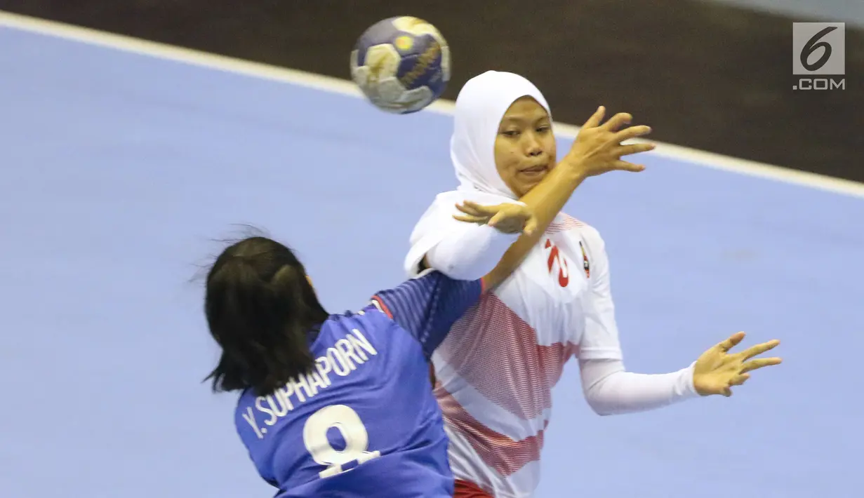 Pemain bola tangan putri Indonesia, Anggun Pramesti (kanan) diadang pemain Thailand, Suphaporn Yaemyim pada babak penyisihan grup B Asian Games 2018 di Jakarta, Kamis (16/8). Indonesia kalah 16-34. (Liputan6.com/Helmi Fithriansyah)