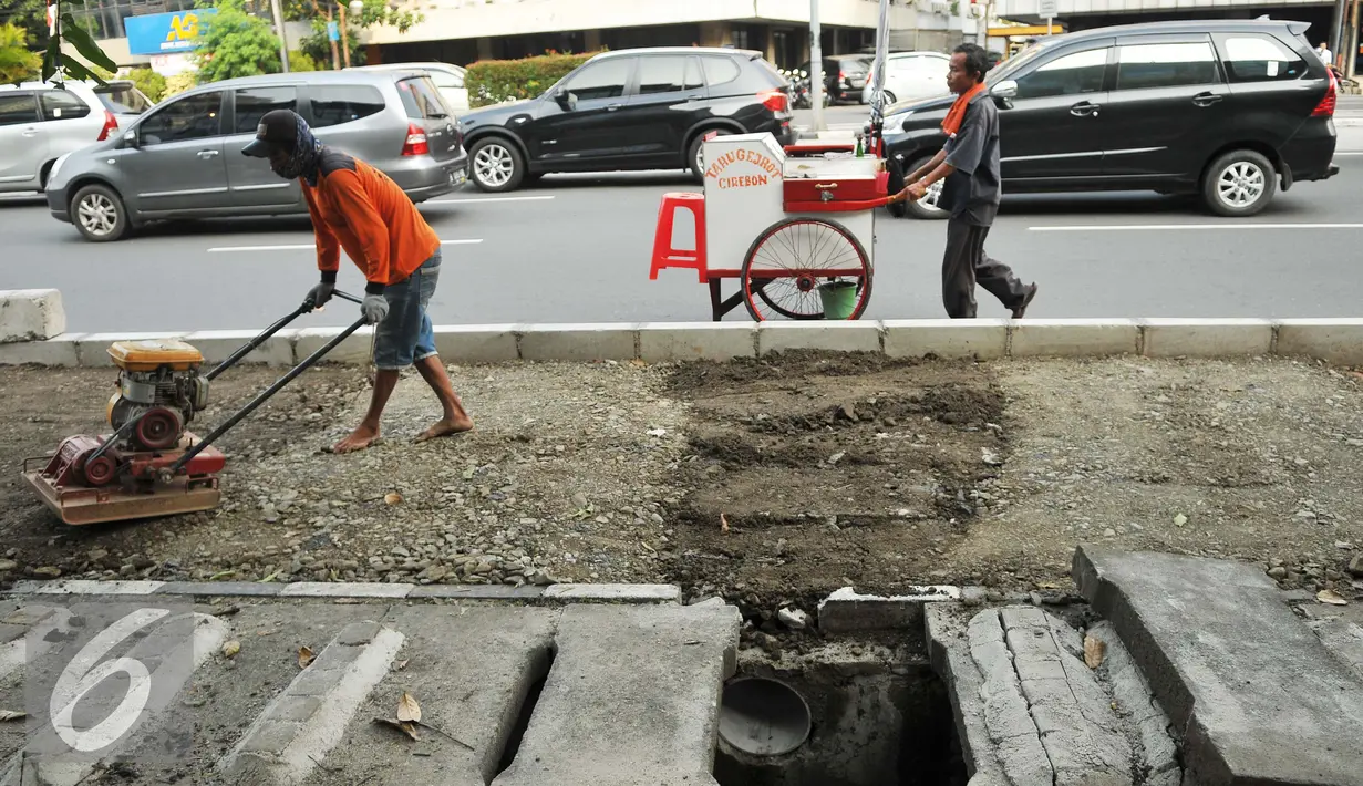 Pekerja meratakan tanah untuk dibangun trotoar di jalan Suryopranoto, Jakarta, Selasa (2/8). Dana sebesar Rp250 miliar telah disiapkan untuk pembangunan trotoar di 48 lokasi. (Liputan6.com/Gempur M Surya) 