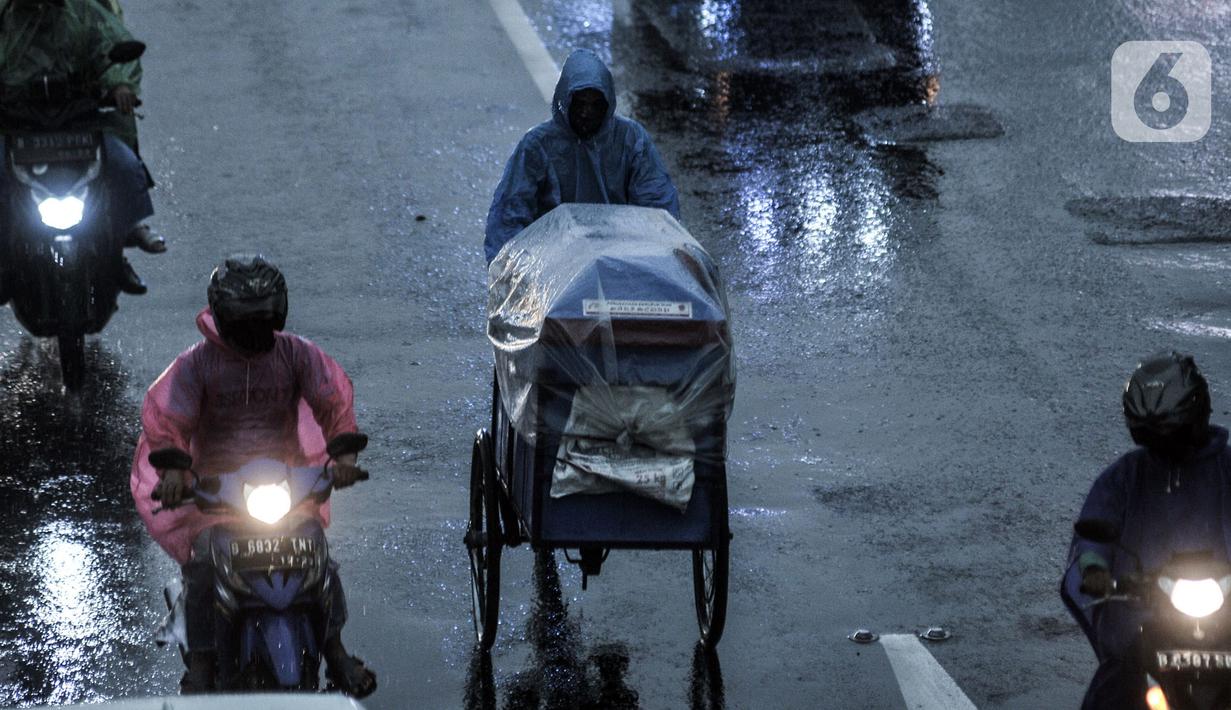 Pedagang melintas saat hujan mengguyur Jakarta, Senin (26/10/2020). BPBD DKI Jakarta mengeluarkan peringatan dini cuaca berupa potensi terjadinya hujan lebat disertai petir dan angin kencang dampak dari siklon tropis Molave hingga 27 Oktober 2020. (merdeka.com/Iqbal S. Nugroho)