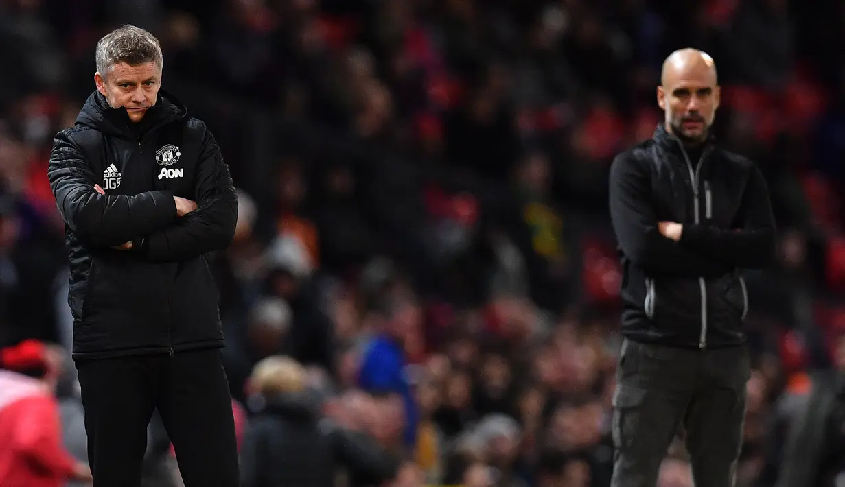 Pelatih Manchester United, Ole Gunnar Solskjaer (kiri) dan pelatih Manchester City, Pep Guardiola menyaksikan pemainnya bertanding pada leg pertama semifinal Piala Liga Inggris di Old Trafford (7/1/2020). City menang 3-1 atas MU. (AFP/Paul Ellis)