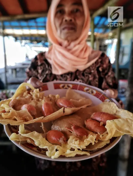 Pedagang menunjukkan peyek undur-undur atau yutuk yang dijual di kawasan wisata Pantai Bocor, Kabupaten Kebumen, Jawa Tengah, Sabtu (05/5). Hasil tangkapannya dijual ke pedagang atau tempat pelelangan ikan. (Liputan6.com/Fery Pradolo)