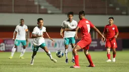 Pemain timnas Indonesia U-16 M Riski Afrisal (25) berebut bola dengan pemain timnas Singapura U-16 pada laga Grup A Piala AFF U-16 2022 di Stadion Maguwoharjo, Rabu (3/8/2022). Pasukan Bima Sakti membantai Singapura U-16 dengan skor telak 9-0. (FOTO: Dok. PSSI)