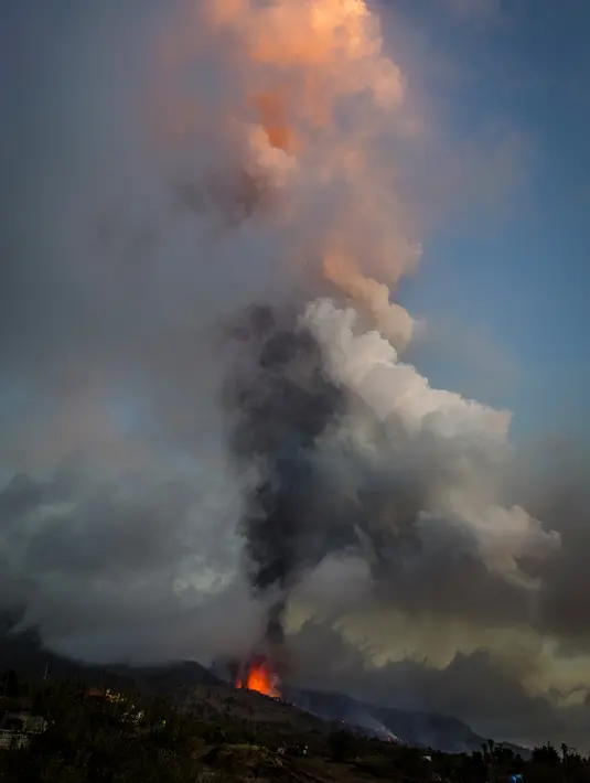 Lava dan asap mengalir dari letusan gunung berapi di pulau La Palma di Kepulauan Canaria, Spanyol, Minggu (19/9/2021). Letusan gunung berapi itu memicu evakuasi besar-besaran terhadap kurang lebih 1.000 penduduk yang tinggal di sekitar Gunung Cumbre Vieja. (AP Photo/Jonathan Rodriguez)