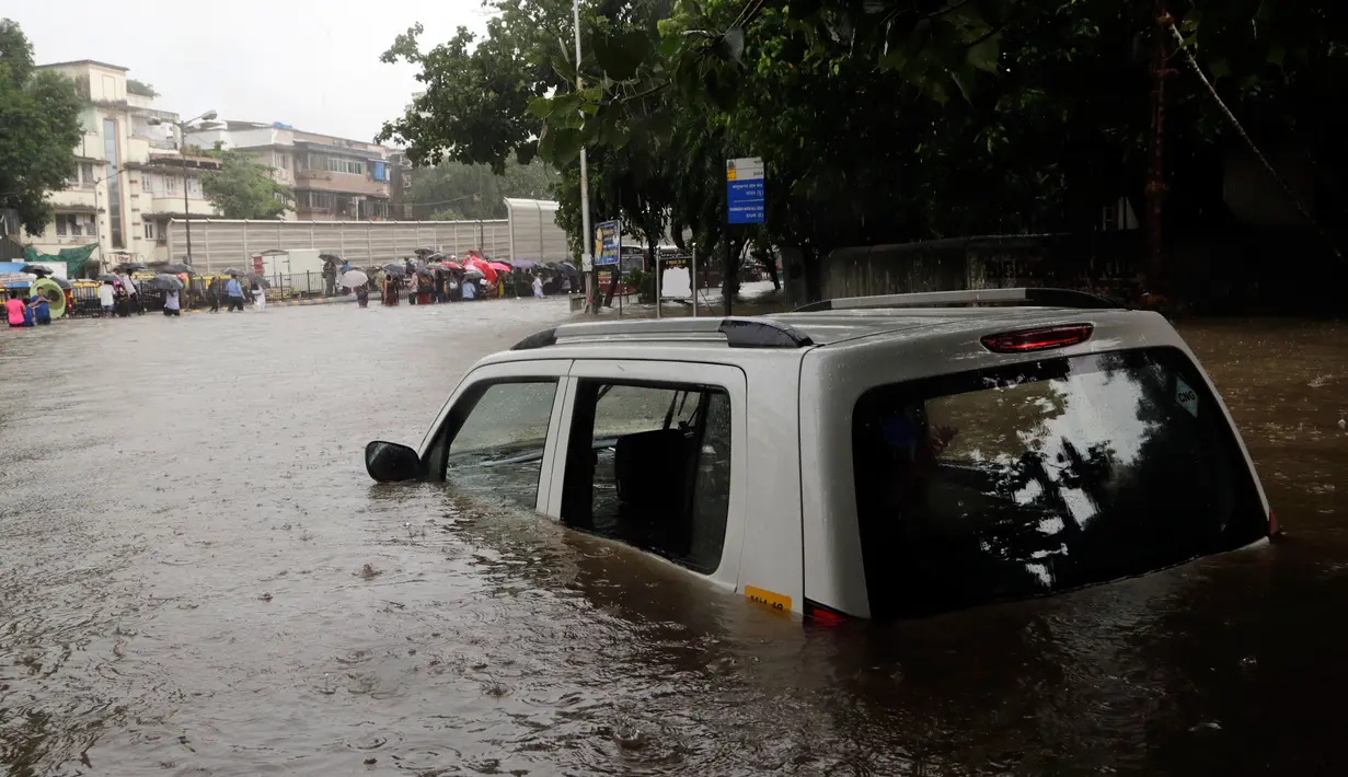 Sebuah mobil yang ditinggalkan di jalanan terendam banjir akibat hujan lebat mengguyur kota Mumbai, India, Selasa (29/8). Beberapa daerah di Mumbai telah terendam oleh banjir dan melumpuhkan beberapa fasilitas umum. (AP Photo/Rajanish Kakade)