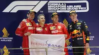 Pembalap Ferrari Sebastian Vettel bersama Charles Leclerc dan Max Verstappen dari Red Bull berpose di podium setelah memenangkan balapan Formula Satu (F1) Grand Prix Singapura di Sirkuit Jalan Marina Bay, Singapura (22/9/2019). (AP Photo/Vincent Thian)