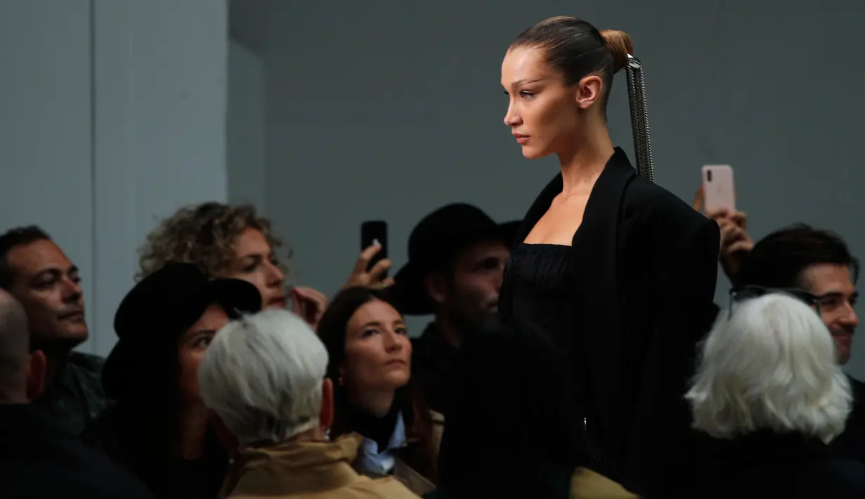 Model Bella Hadid mengenakan membawakan koleksi Spring 2020 dari Mugler dalam gelaran Paris Fashion Week, Rabu (25/9/2019). Bella Hadid menonjolkan bentuk alis serta matanya yang dirias ala smokey eye, dengan sapuan warna emas pada bibirnya. (AP Photo/Francois Mori)