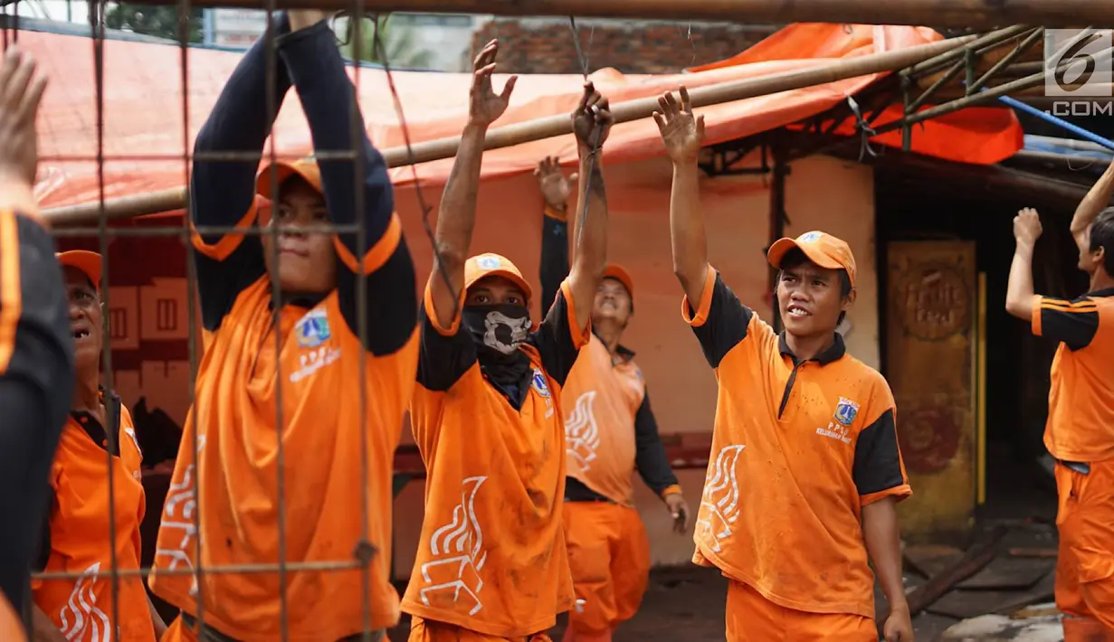Petugas PPSU membongkar bangunan kios pedagang nasi kapau di Jalan Kramat Raya, Senen, Jakarta, Jumat (6/9/2019). Pembongkaran disebabkan adanya rencana revitalisasi trotoar di jalan tersebut. (Liputan6.com/Immanuel Antonius)