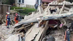 Tim penyelamat berusaha mencari korban di reruntuhan sebuah apartemen tua yang ambruk di Swiebodzce, Polandia, Sabtu (8/4). Pemadam kebakaran dan anjing pelacak masih mencari korban hilang di antara reruntuhan bangunan. (Natalia DOBRYSZYCKA/AFP)