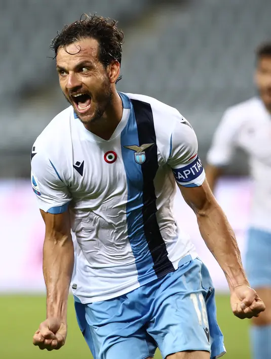 Gelandang Lazio, Marco Parolo  berselebrasi usai mencetak gol ke gawang Torino pada pertandingan lanjutan Liga Serie A Italia di stadion Olimpiade di Turin (30/6/2020). Lazio menang tipis atas Torino 2-1. (AFP Photo/Isabella Bonotto)