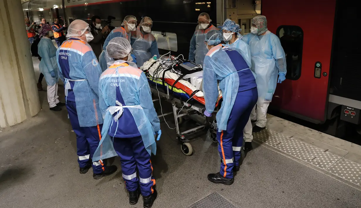 Petugas medis membawa pasien virus corona COVID-19 di Stasiun Gare d'Austerlitz di Paris, Prancis, Rabu (1/4/2020). Prancis mengerahkan kereta kecepatan tinggi untuk mengevakuasi pasien COVID-19 dari Paris ke wilayah Brittany. (Thomas SAMSON/AFP/POOL)