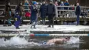Para perenang bertanding saat kompetisi renang musim dingin di lubang es sepanjang 25 meter di sebuah danau dekat Vilnius, Lithuania, Sabtu (6/3/2021).  Suhu air saat itu 3 derajat Celcius, sedangkan udaranya -3 derajat Celsius. (AP Photo/Mindaugas Kulbis)