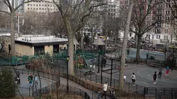 Orang-orang menikmati cuaca seperti musim semi di Morningside Park di New York (11/3/2021).  Cuaca hangat yang tidak wajar membuat warga New York keluar setelah awal tahun bersalju. (AP Photo / Seth Wenig)