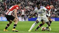 Penyerang Real Madrid Vinicius Junior berebut bola saat dijamu Athletic Bilbao pada perempat final Copa del Rey di San Mames, Jumat (4/2/2022) dinihari WIB. Real Madrid tersisih dari Copa del Rey setelah kalah 0-1 dari Athletic Bilbao. (AP Photo/Alvaro Barrientos)