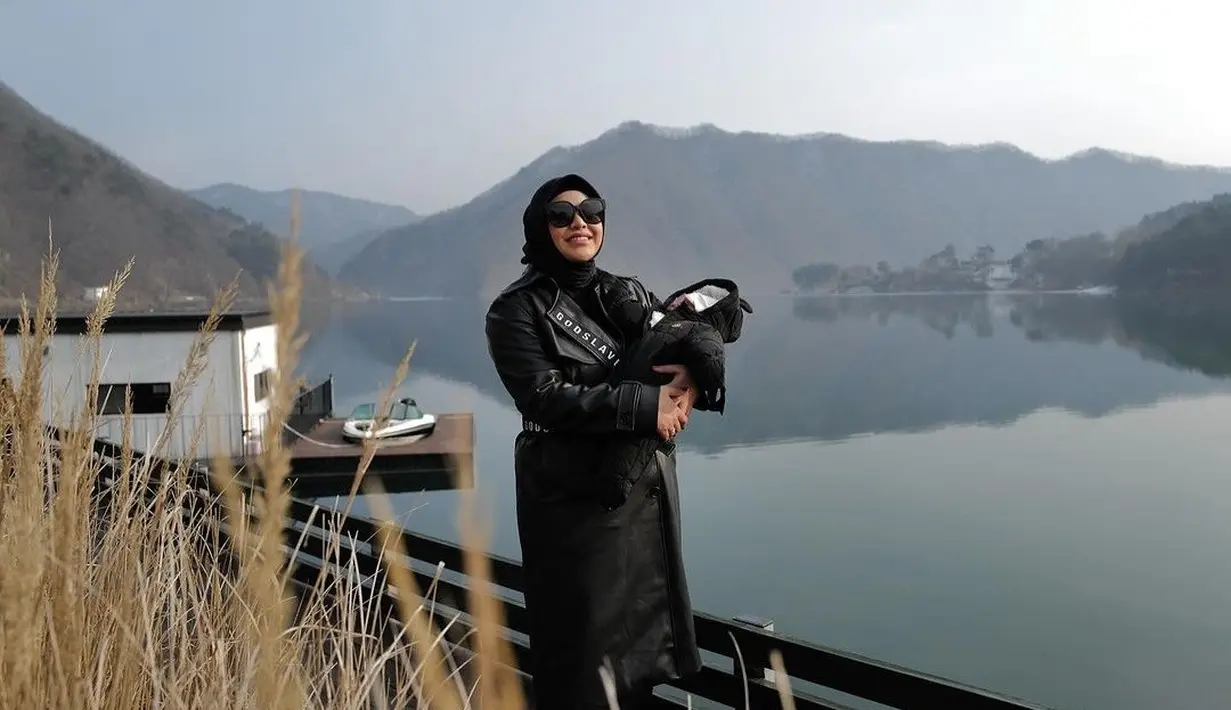 Aurel sempat memakai outer dan sunglesses sambkl menggendong Azura saat menikmati pemandangan danau