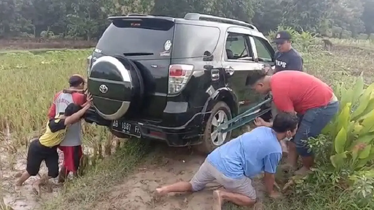 Mobil Rizki yang tersesat di sawah saat dievakuasai warga. (Ahmad Adirin/Liputan6.com)