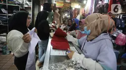 Aktivitas jual beli seragam sekolah di Pasar Kebayoran Lama, Jakarta, Jumat (8/7/2022). Menjelang dimulainya tahun ajaran baru, para orang tua disibukkan berbelanja baju seragam dan perlengkapan sekolah untuk anak mereka. (Liputan6.com/Angga Yuniar)