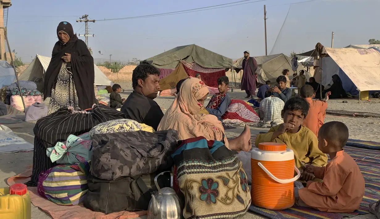 Keluarga Afghanistan duduk di luar tenda mereka di area terbuka di pinggiran Chaman, sebuah kota perbatasan di provinsi Baluchistan barat daya Pakistan, Selasa (31/8/2021). AS mengakhiri kehadiran militernya selama 20 tahun di negara yang dikuasai Taliban. (AP Photo)