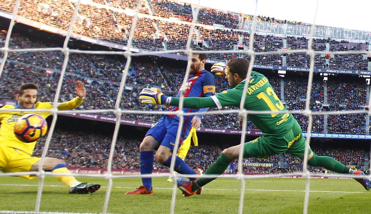 Pemain FC Barcelona, Lionel Messi (tengah) mengecoh kiper dan pemain Las Palmas saat mencetak gol pada laga La Liga di Camp Nou, Barcelona (14/1/2017). Barcelona menang 5-0. (AP/Manu Fernandez)