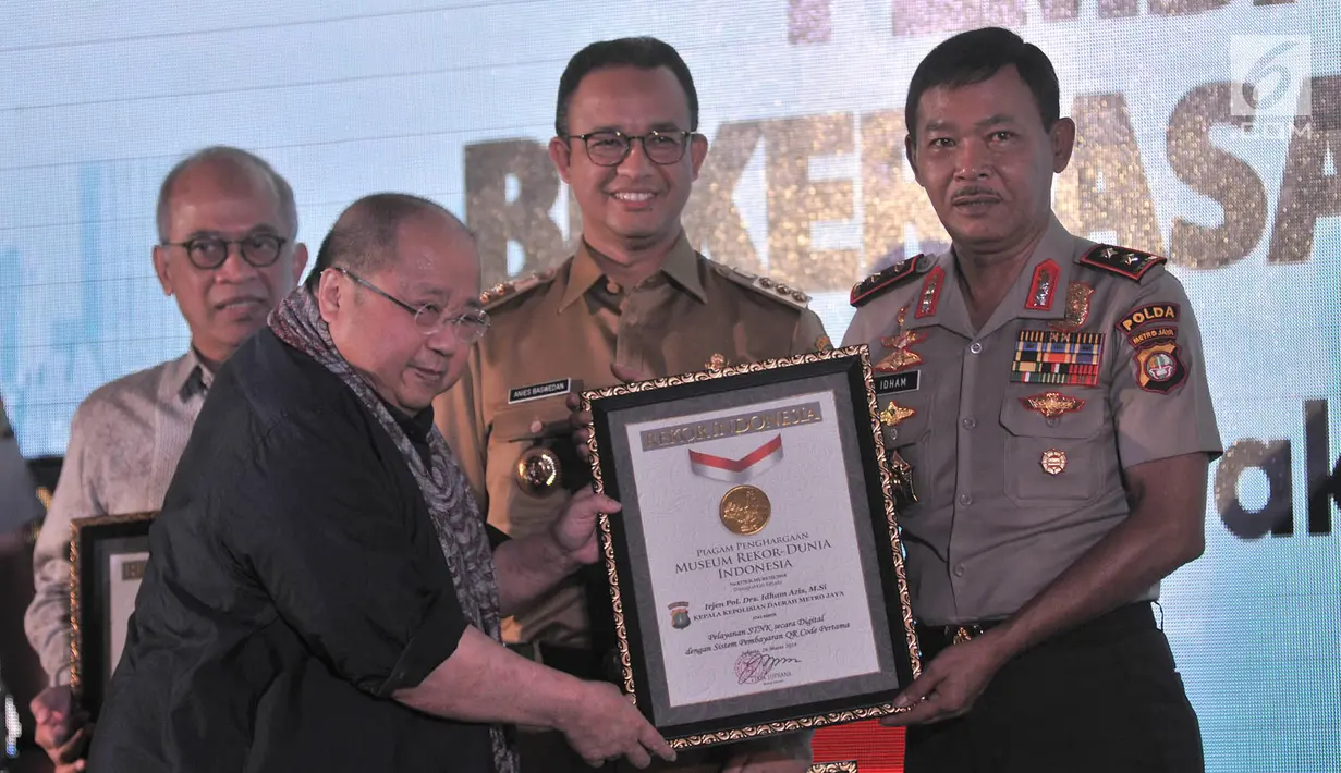 Jaya Suprana memberikan piagam Rekor MURI kepada Kapolda Metro Jaya Irjen Pol Idham Aziz dan Gubernur DKI Jakarta Anies Baswedan saat peresmian Samsat Digital di Jakarta, Senin (26/3). (Merdeka.com/Iqbal Nugroho)