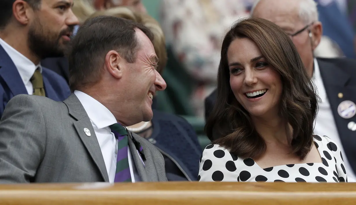 Kate Middleton berbincang dengan penonton lainnya saat menyaksikan pertandingan antara petenis asal Inggris, Andy Murray melawan petenis Rusia, Alexander Bublik pada babak pertama Wimbledon di London, Inggris (3/7). (AFP Photo/Adrian Dennis)