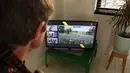 Seorang pria menyaksikan Tour of Flanders yang diselenggarakan secara virtual di sebuah televisi, di Vilvoorde (5/4/2020). Balap sepeda virtual ini digelar untuk menggantikan Tour of Flanders 2020 yang ditunda penyelenggaraannya lantaran meluasnya penyebaran Covid-19. (AFP/Belga/Nathalie Willems)