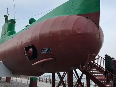 Pengunjung menaiki sebuah kapal selam Korea Utara yang dipamerkan di "Taman Unifikasi" tepi laut di Gangneung, Korea Selatan, (18/2). Pameran kapal selam ini diadakan dekat acara skating, hoki dan curling Olimpiade Pyeongchang 2018. (AP Photo/Johnson Lai)