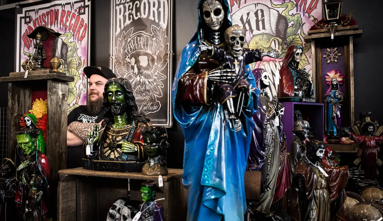 Seorang pria menjual patung dan aksesoris saat acara Konvensi Tattoo Paris (Mondial du Tatouage) di Grand Halle de la Villette di Paris (8/3). Dalam acara ini juga dijual berbagai pernak-pernik dan aksesoris. (AFP/Philippe Lopez)