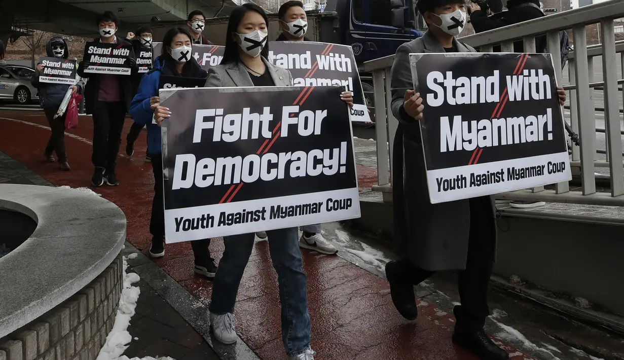 Anggota kelompok pemuda membawa poster berbaris menuju kedutaan Myanmar selama unjuk rasa di Seoul, Korea Selatan, Jumat (5/2/2021). Mereka menentang kudeta militer dan mendukung demokrasi Myanmar. (AP Photo/Lee Jin-man)