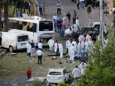 Petugas ahli forensik melakukan olah TKP di lokasi ledakan sebuah bom mobil di kota Diyarbakir, Turki, Selasa (10/5). Ledakan menghantam kendaraan lapis baja polisi, setidaknya ada tiga korban tewas dan puluhan mengalami luka-luka. (REUTERS/Sertac Kayar)