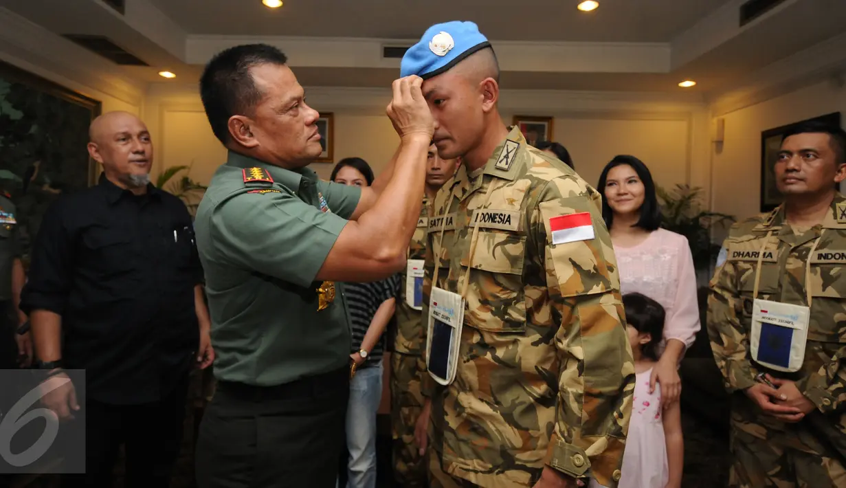 Panglima TNI Jenderal TNI Gatot Nurmantyo (kedua kiri) memasangkan baret pasukan perdamaian pada pemeran utama film ”I Leave My Heart In Lebanon-Garuda 23” Rio Dewanto di Bandara Halim Perdanakusuma Jakarta, Jumat (29/7). (Liputan6.com/Helmi Fithriansyah)