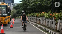 Pengendara sepeda melintas di jalan Sudirman, Jakarta, Jumat (19/6/2020). Direktorat Lalu Lintas Polda Metro Jaya mengingatkan pesepeda untuk berkendara di jalurnya. Pesepeda yang keluar dari jalurnya bisa dikenai denda tilang Rp 100 ribu. (Liputan6.com/Faizal Fanani)