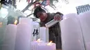 Seorang orang wanita menyalakan lilin untuk mendoakan keberhasilan anak dan kerabatnya dalam mengikuti tes kemampuan Skolastik College tahunan di Seoul (23/11). (AFP Photo/Jung Yeon-Je)